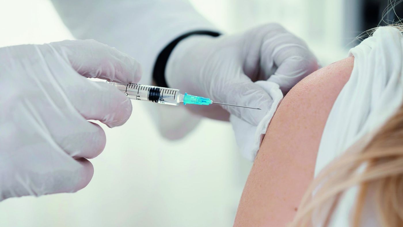 Pharmacist giving a vaccine in the upper arm